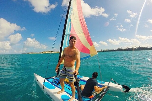 a man riding on the back of a boat in a body of water