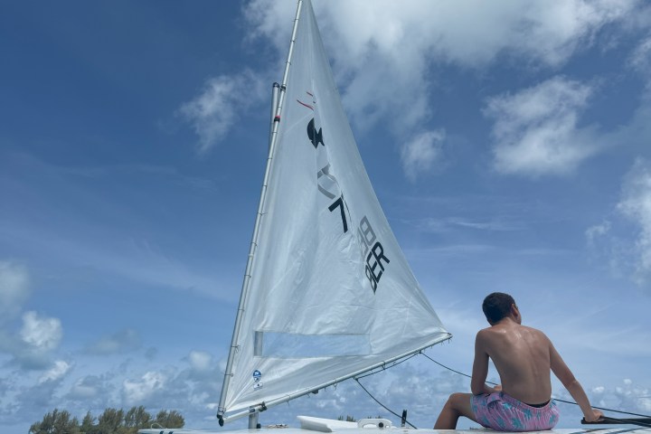 a man riding on the back of a boat in the water