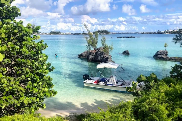a boat floating along a river next to a body of water