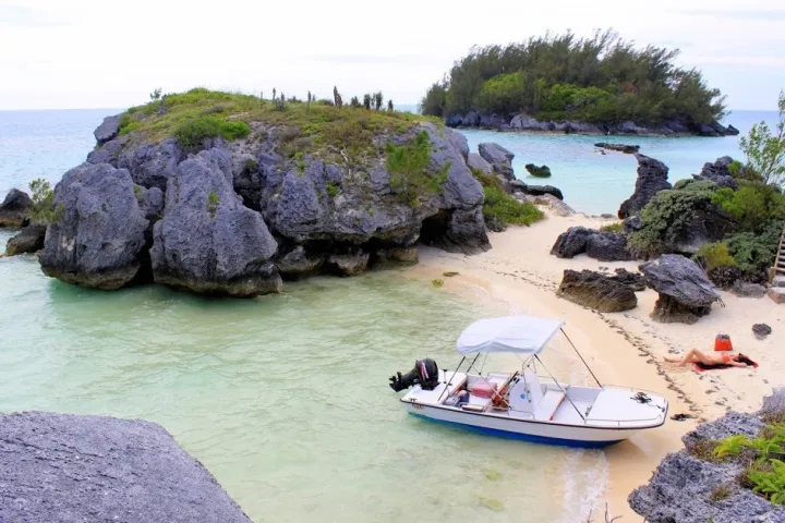 a group of people sitting on a rock next to a body of water