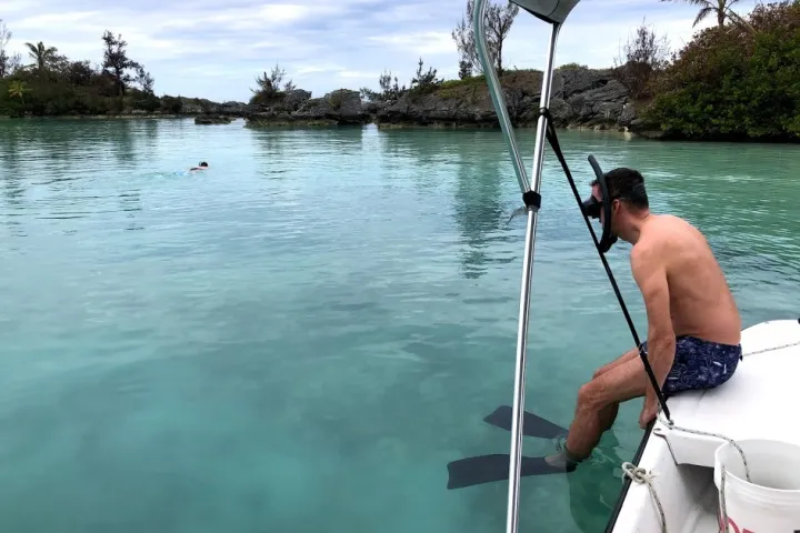 a man standing next to a body of water