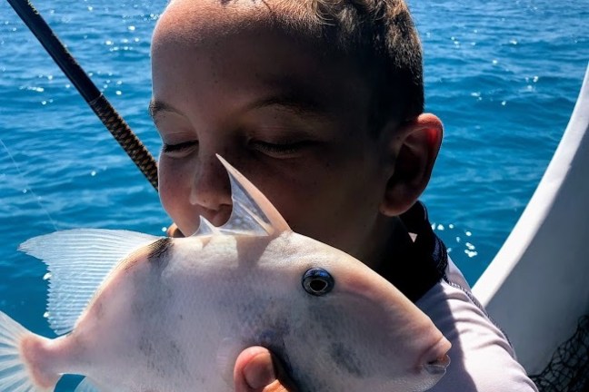 a man drinking out of a body of water