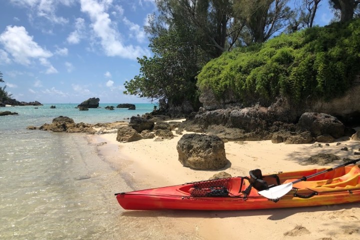 a red and white boat sitting next to a body of water