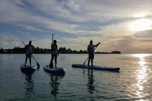 a group of people riding on the back of a boat in the water