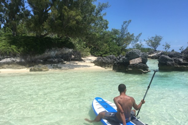 a man standing next to a body of water